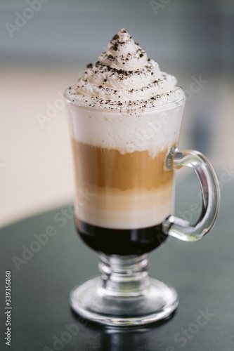 A coffee drink with whipped cream outside on a sunny day 