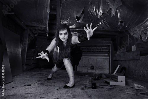 Eine junge Frau als Untote, Zombie oder Geist in einem alten Haus in schwarz-weiß