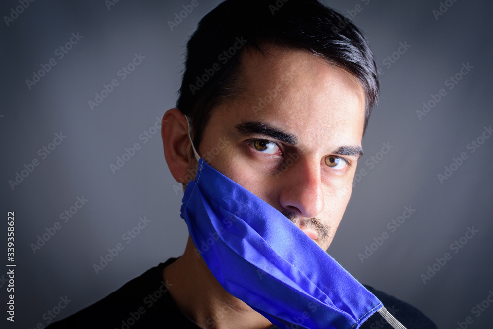 junk himmelsk køretøj Man taking off mask with protective mask on face against Coronavirus.  COVID-19 Pandemic Coronavirus. Man Portrait with homemade mask. Young man  with homemade protective mask, with Black Tshirt. Stock-foto | Adobe Stock