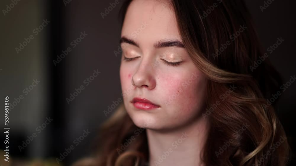 Makeup artist paints eyelids on a model girl. Makeup artist paints eyelids on a model girl.