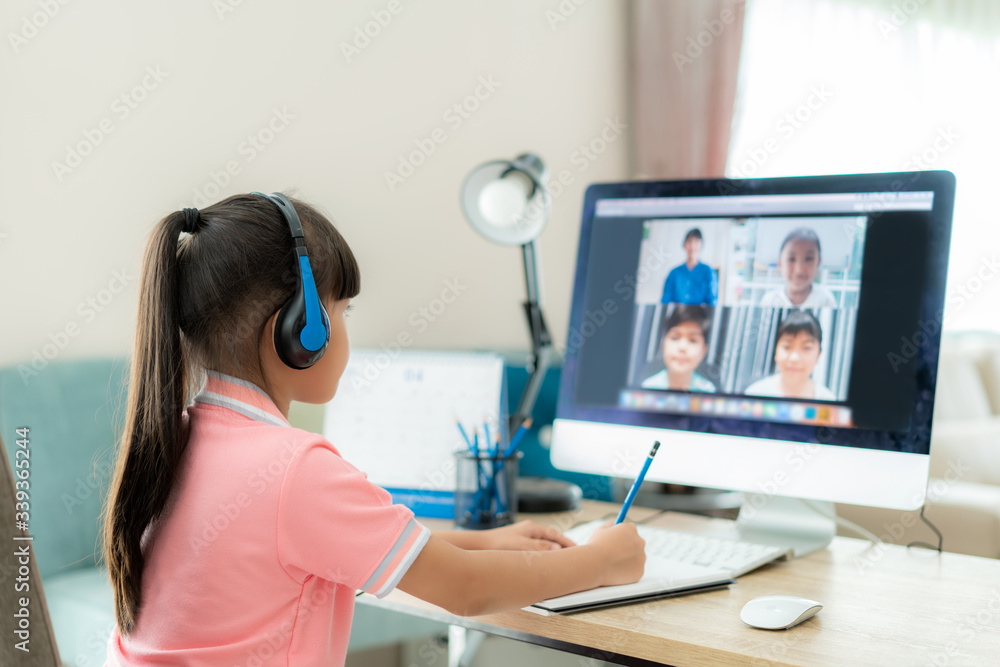 Asian girl student video conference e-learning with teacher and classmates on computer in living room at home. Homeschooling and distance learning ,online ,education and internet. Asian girl student video conference e-learning with teacher and classmates on computer in living room at home. Homeschooling and distance learning ,online ,education and internet.