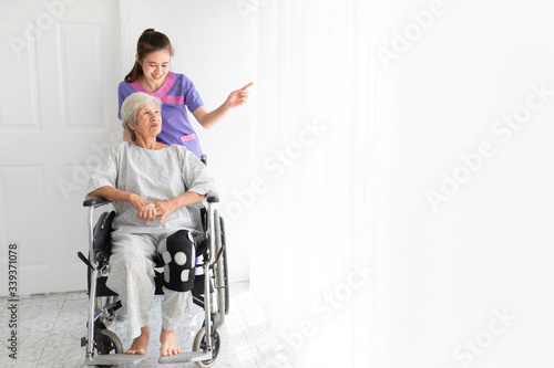 asian female nurse talk about rehabilitation process with old stroke patient in hospital, they feeling happy and smile, old asian people sitting on wheelchair, elderly healthcare