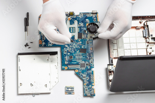Φωτογραφία Details of disassembled laptop and male hands in white gloves, laptop repair con