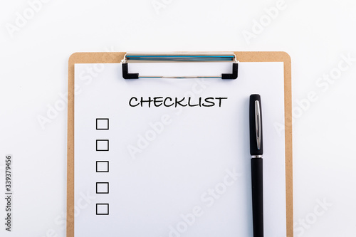 "CHECKLIST" concept. Note pad and white paper on white background, copy space