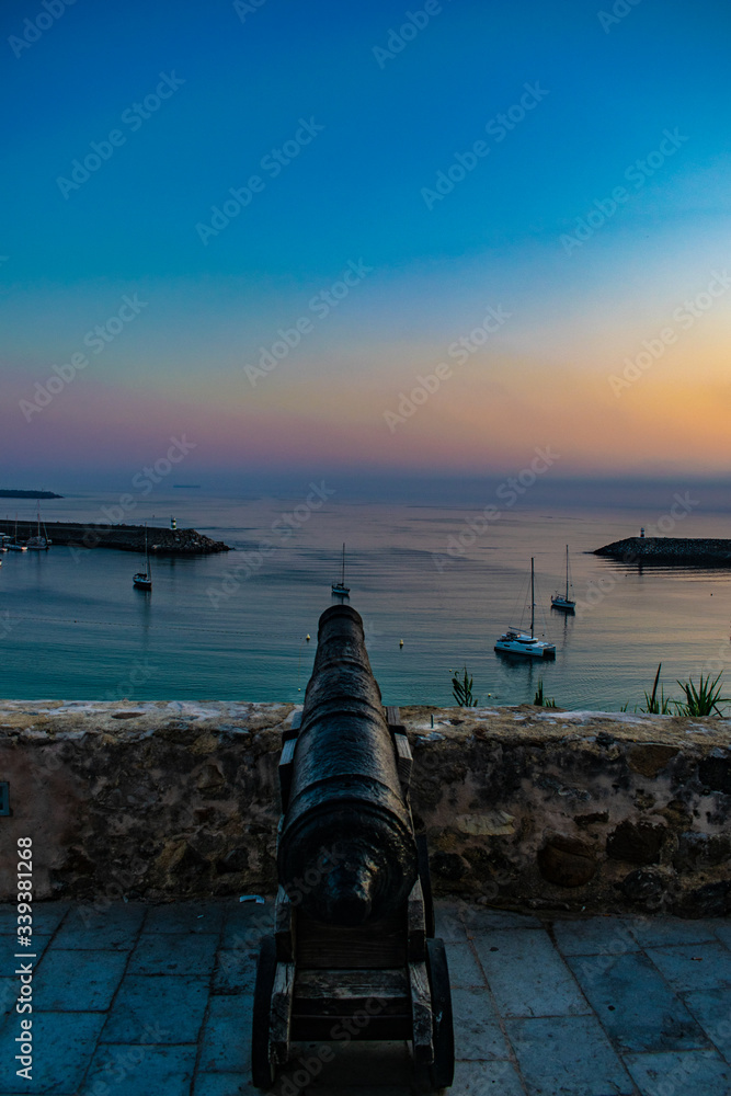 Cannon aiming at the beach at sunset
