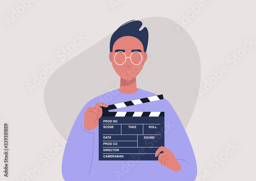 Movie production, young male character holding a clapper board, video industry