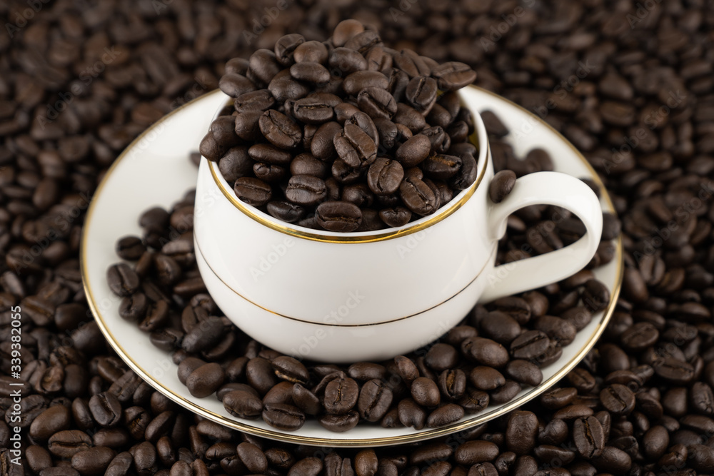Coffee cup with roasted beans on coffee beans background Coffee cup with roasted beans on coffee beans background