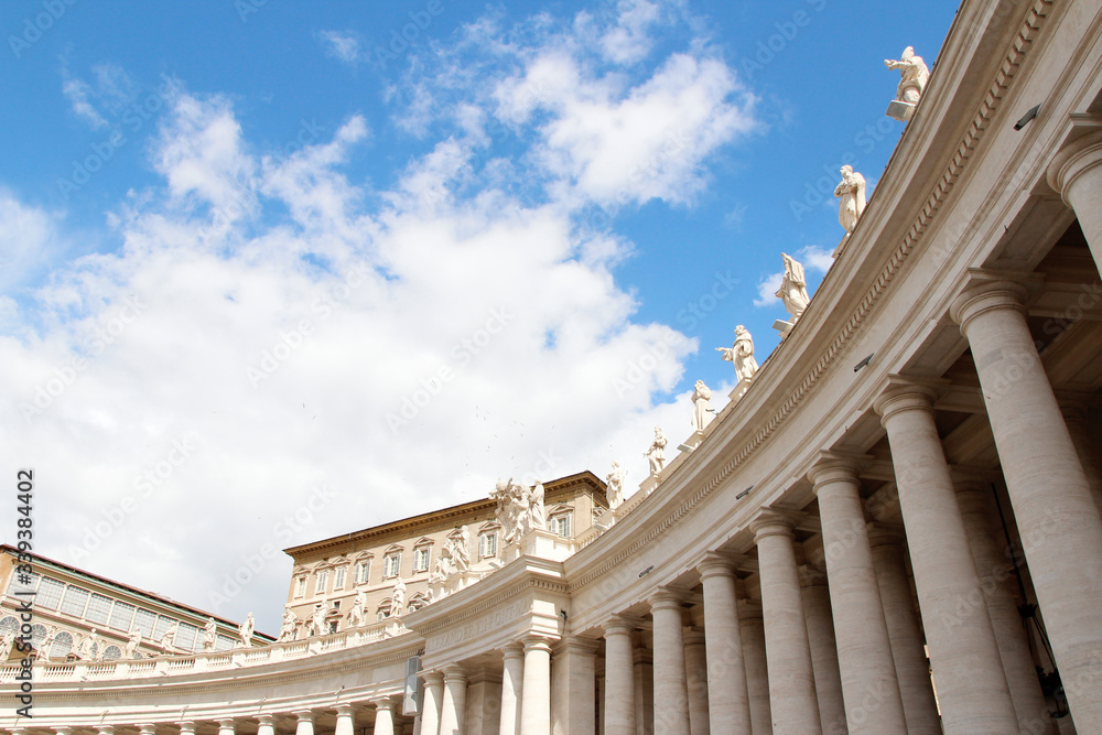 Fototapeta premium A group of Saint Statues on the colonnades of St Peter's Square with blue sky and clouds in Vatican City, Rome, Italy