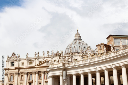 Fotografia A group of Saint Statues on the colonnades of St Peter's Square with dome in Vat