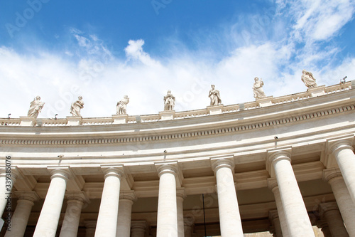 Tablou canvas A group of Saint Statues on the colonnades of St Peter's Square with blue sky an