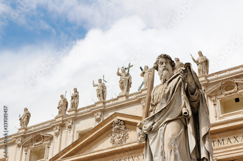 Statue of St. Paul with sword in front of St Peter s Basilica with blue sky and clouds in Vatican City  Rome  Italy