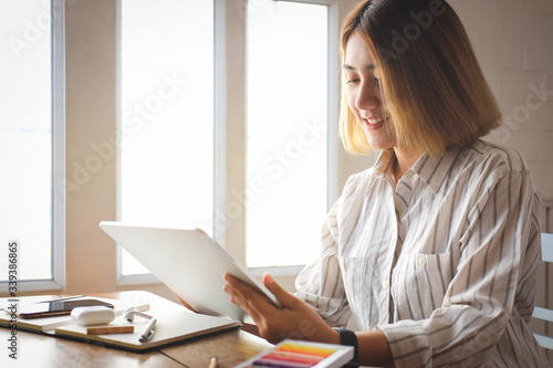 Woman working from home on laptop computer while sitting at the living room  drinking coffee
