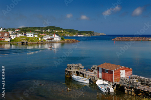 Quiet water of Twillingate Harbour Newfoundland with lobster traps on dock and village houses
