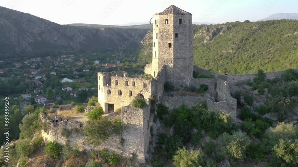 Abandoned castle over village on top of mountain. Panning shot, drone flight Abandoned castle over village on top of mountain. Panning shot, drone flight