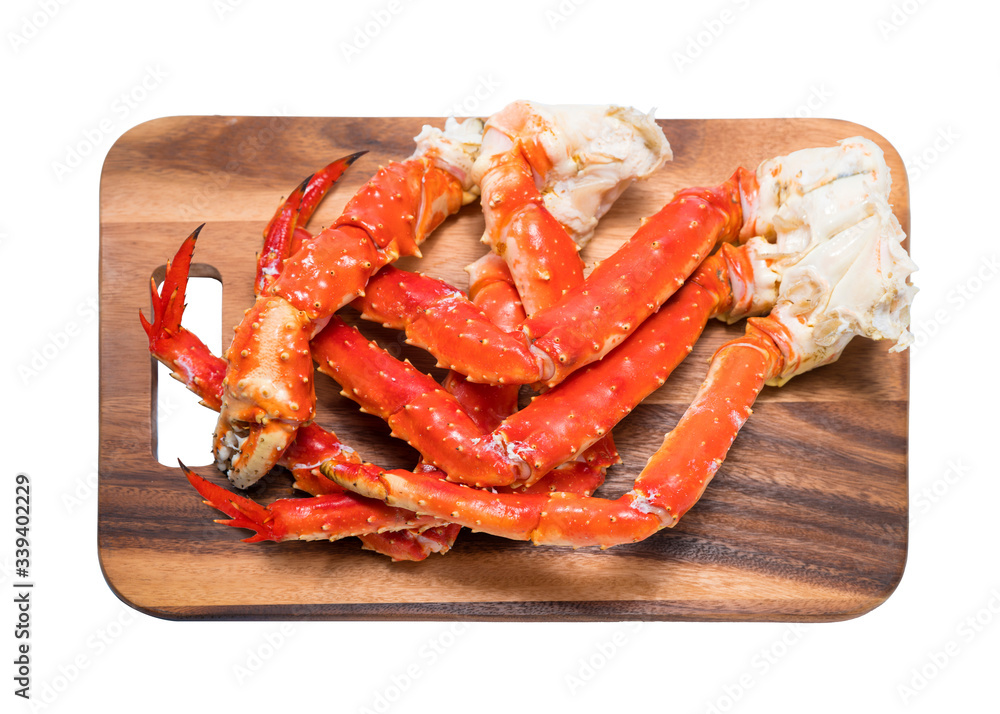 Cooked Organic Alaskan King Crab Legs with Butter and lemons, Alaskan King Crab on wood plate in white background. Cooked Organic Alaskan King Crab Legs with Butter and lemons, Alaskan King Crab on wood plate in white background.