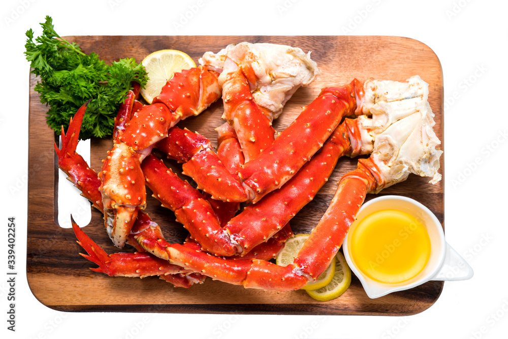 Cooked Organic Alaskan King Crab Legs with Butter and lemons, Alaskan King Crab on wood plate in white background. Cooked Organic Alaskan King Crab Legs with Butter and lemons, Alaskan King Crab on wood plate in white background.
