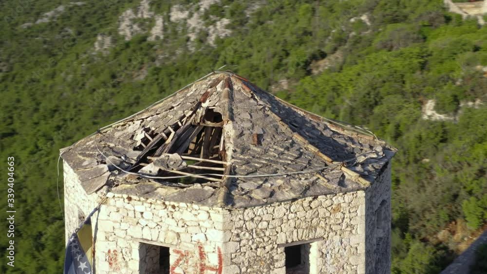 All-round view of castle tower with broken roof at base of mountain with view of a village. All-round view of castle tower with broken roof at base of mountain with view of a village.