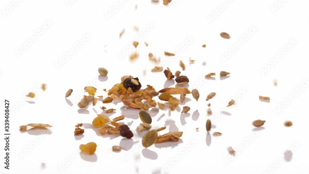 Slow motion speed close up scene of granola dropping on floor on white background, muesli texture, pattern of seed scattered falling and bounce on ground, cereal grain for good health, food industrial Slow motion speed close up scene of granola dropping on floor on white background, muesli texture, pattern of seed scattered falling and bounce on ground, cereal grain for good health, food industrial