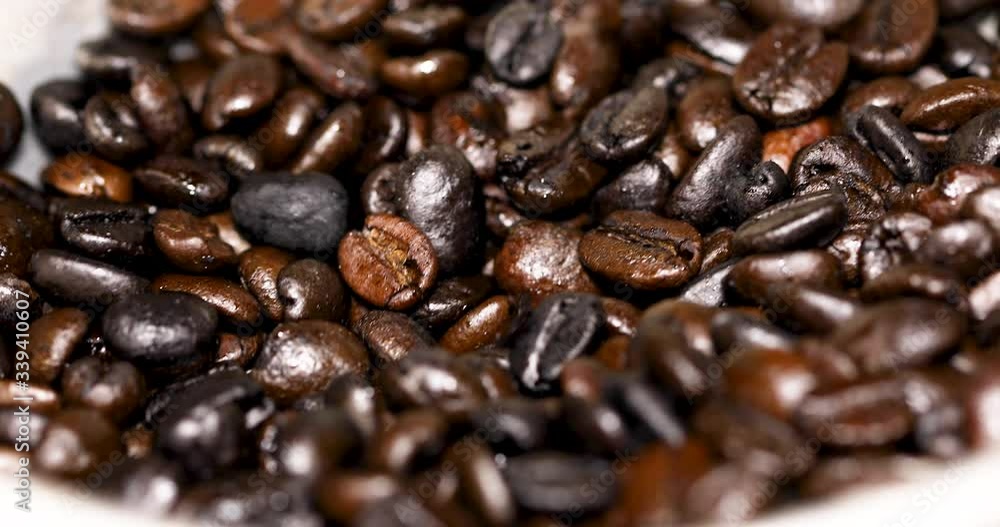 Roasted coffee beans falling into the grinder Roasted coffee beans falling into the grinder