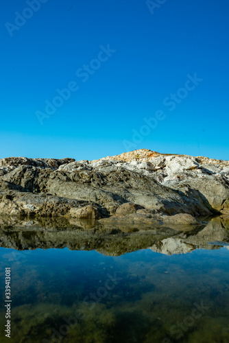 reflection of rocks on the sea