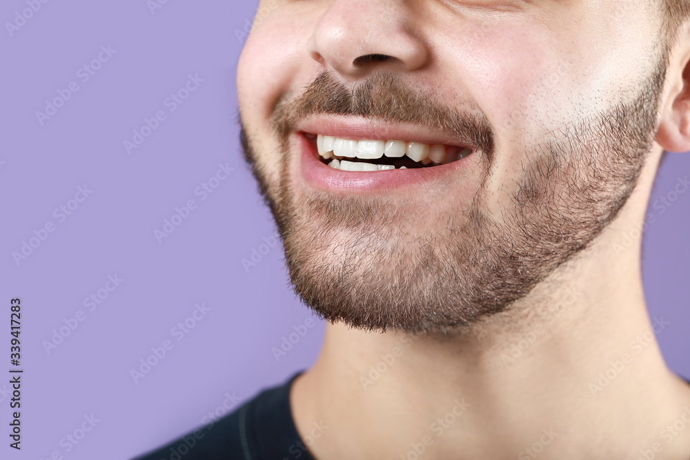 Handsome smiling young man on color background, closeup