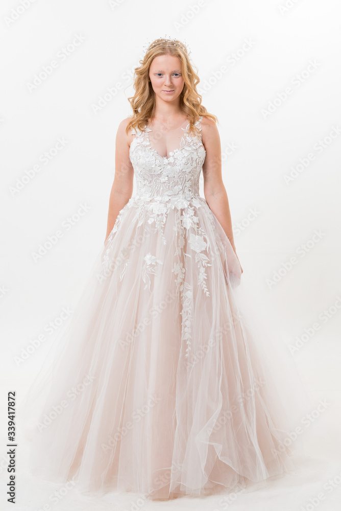 Romantic young bride isolated on white in white lace wedding dress with makeup and wavy blonde hair with pearl jewelry getting ready in bride's morning. Fine art wedding. Romantic young bride isolated on white in white lace wedding dress with makeup and wavy blonde hair with pearl jewelry getting ready in bride's morning. Fine art wedding.
