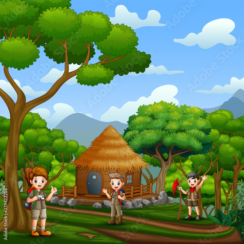 The scouts in front a wooden cottage in the forest