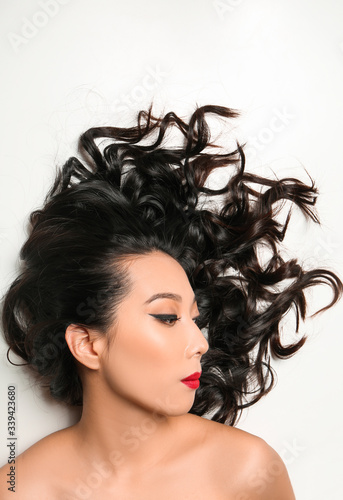 Young Asian woman with beautiful hair on white background