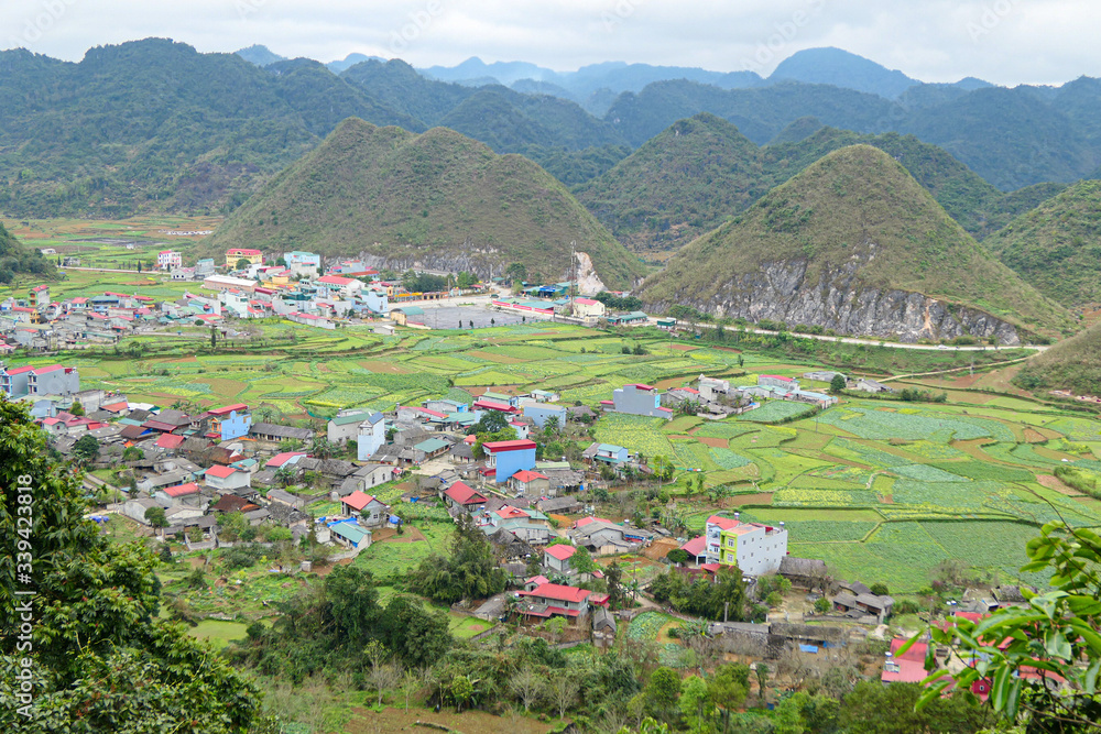 Green valley with hills in mountains. Village in the valley.