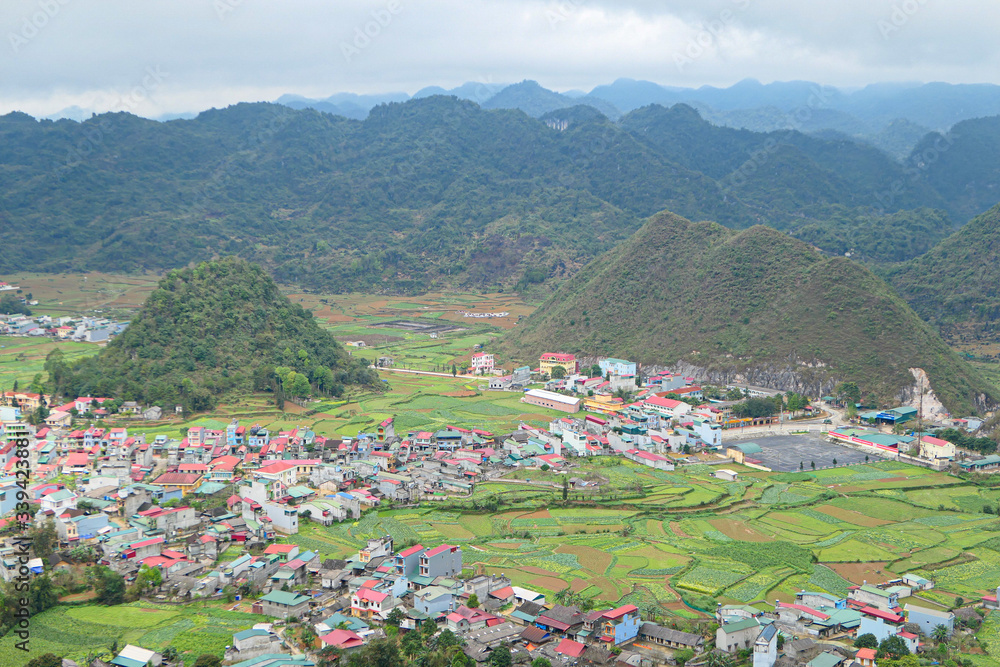 Green valley with hills in mountains. Village in the valley.