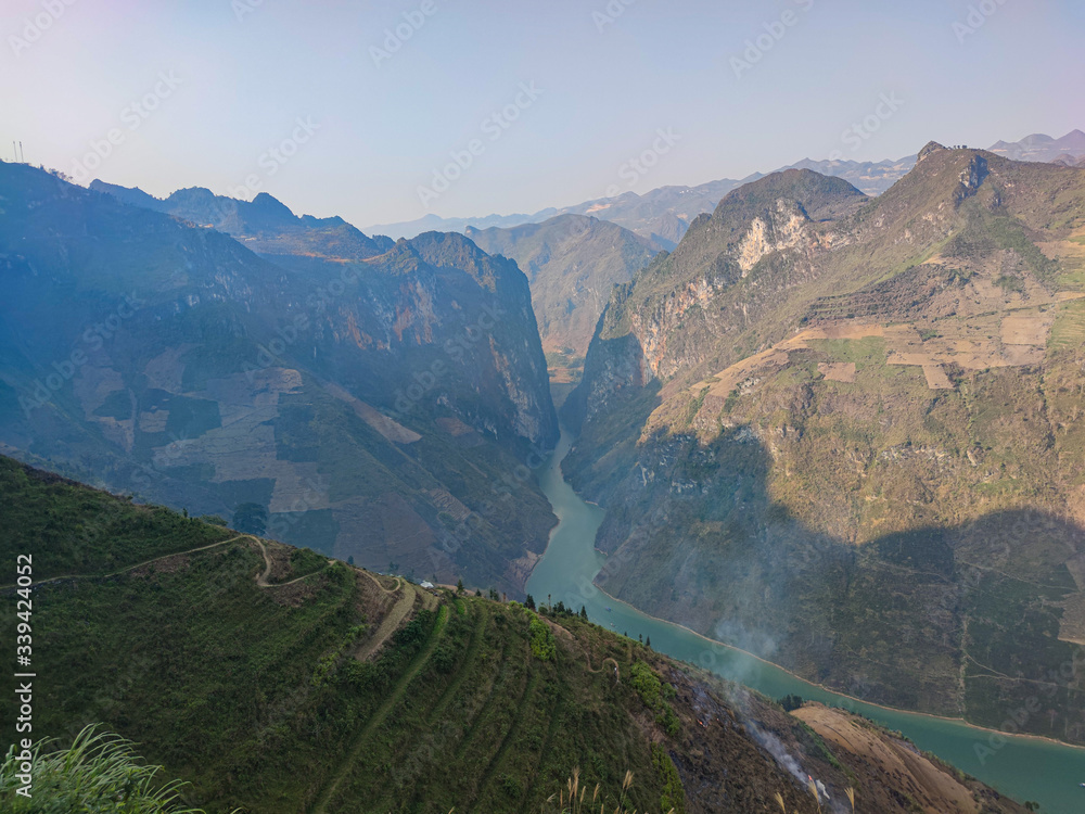 Fototapeta premium Long blue river in canyon. View from the green mountains.