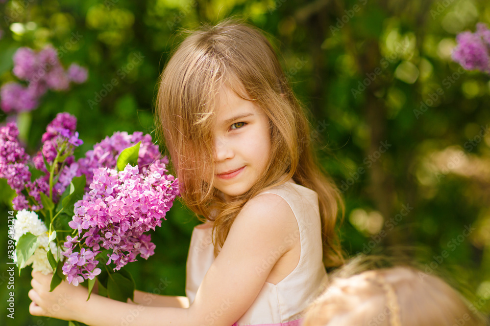 little girl in near a lilac flowers with bouquet little girl in near a lilac flowers with bouquet