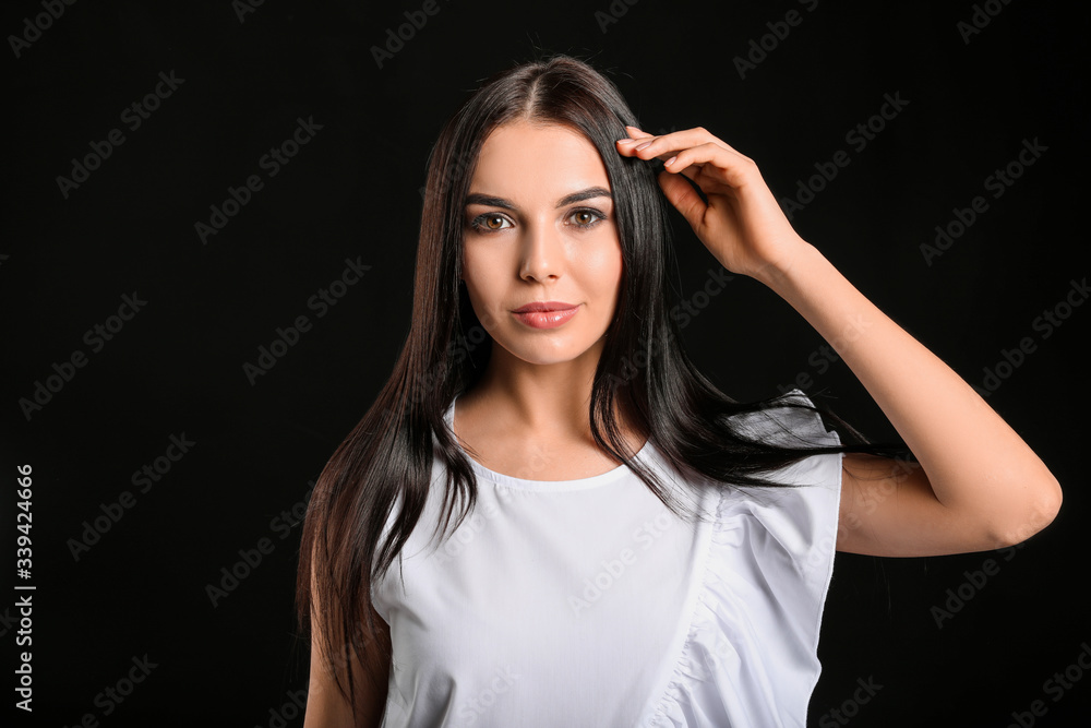 Naklejka premium Young woman with beautiful healthy hair on dark background