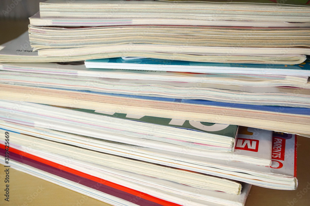 a stack of glossy magazines is on the table a stack of glossy magazines is on the table