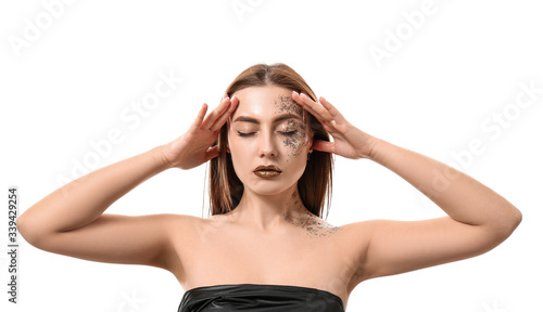 Fashionable young woman with glitters on her body against white background © Pixel-Shot
