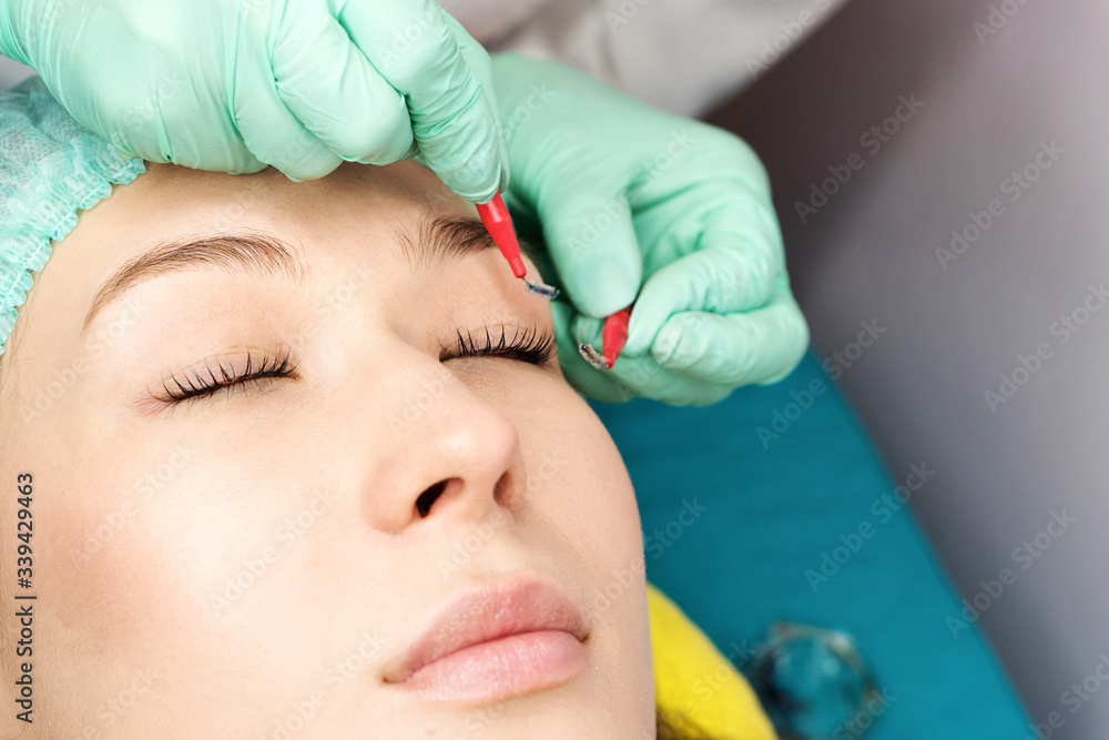 Young woman undergoing procedure of eyelashes lamination in beauty salon, closeup. Cosmetic procedure of eyelash care at the stage of combing, laminating lashes Young woman undergoing procedure of eyelashes lamination in beauty salon, closeup. Cosmetic procedure of eyelash care at the stage of combing, laminating lashes