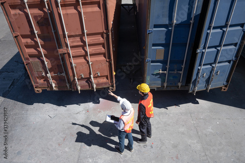 Foreman control loading containers box from cargo freight ship for import export, Foreman control industrial container cargo freight ship, Business import and export logistic concept.