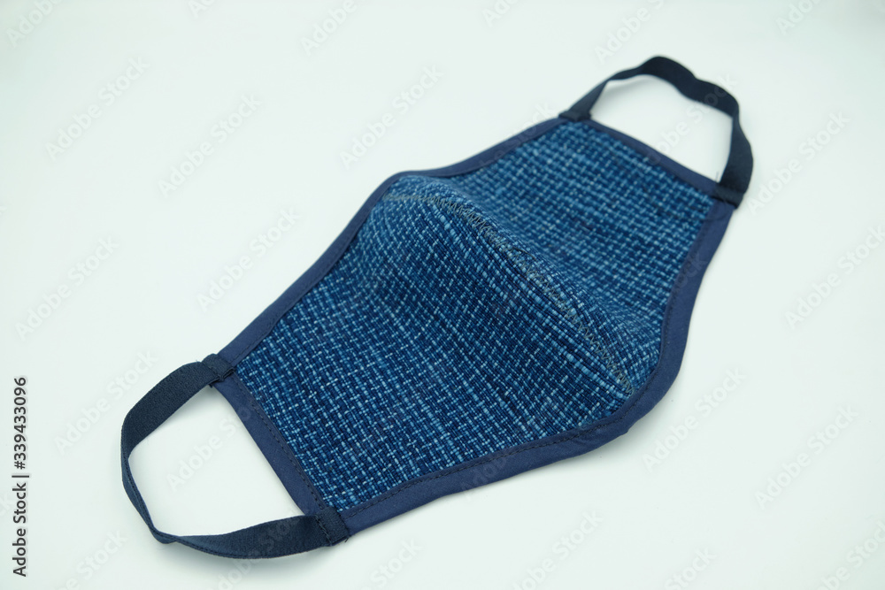 Blue indigo woven fabric cloth face mask For covid19 virus protection, made from woven fabric cotton for wearing to protect against Coronavirus isolated on a white background. Blue indigo woven fabric cloth face mask For covid19 virus protection, made from woven fabric cotton for wearing to protect against Coronavirus isolated on a white background.
