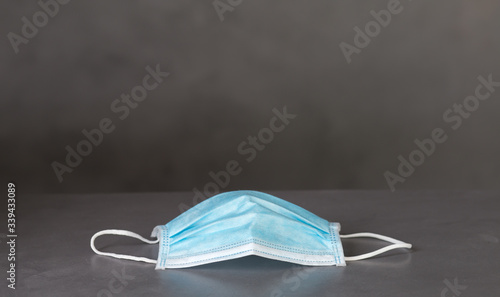 Medical mask on dark table with dark background