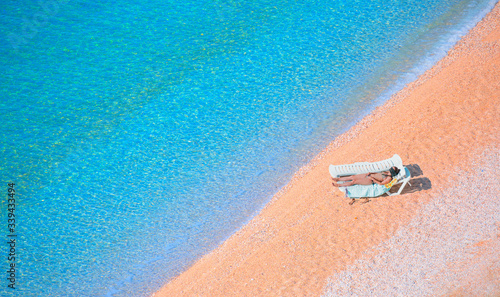 Young woman in bikini lying on the beach under the bright sun - Kaputas beach
