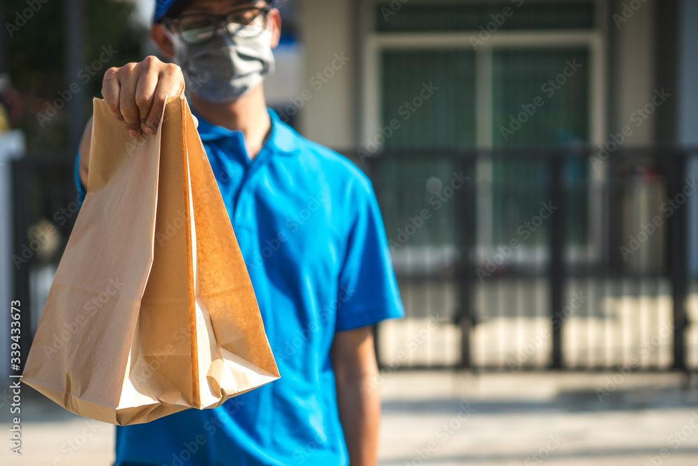 Asian delivery man wearing mask delivers parcel, customer in medical gloves signs on tablet. Delivery service under quarantine, disease outbreak, coronavirus covid-19 pandemic conditions. Asian delivery man wearing mask delivers parcel, customer in medical gloves signs on tablet. Delivery service under quarantine, disease outbreak, coronavirus covid-19 pandemic conditions.