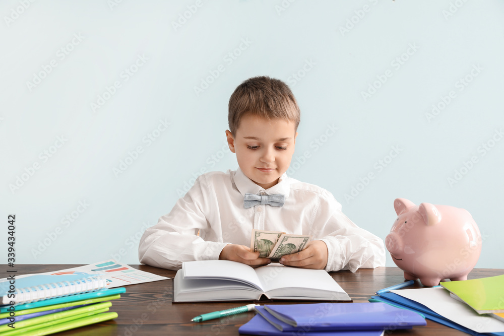 Little accountant at table against grey background Little accountant at table against grey background
