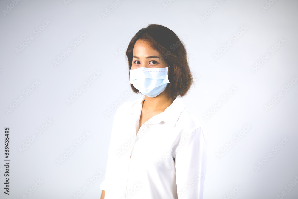Studio portrait of Asian woman wearing face medical surgical mask, looking at camera, isolated on white background. Mask protection against virus. Covid-19, coronavirus pandemic Studio portrait of Asian woman wearing face medical surgical mask, looking at camera, isolated on white background. Mask protection against virus. Covid-19, coronavirus pandemic
