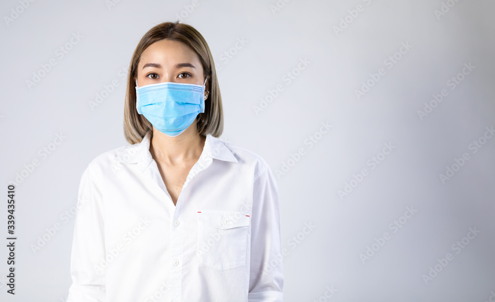 Studio portrait of Asian woman wearing face medical surgical mask, looking at camera, isolated on white background. Mask protection against virus. Covid-19, coronavirus pandemic Studio portrait of Asian woman wearing face medical surgical mask, looking at camera, isolated on white background. Mask protection against virus. Covid-19, coronavirus pandemic