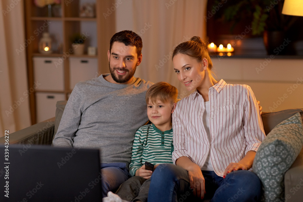family, leisure and people concept - happy smiling father, mother and little son with remote control watching tv at home at night family, leisure and people concept - happy smiling father, mother and little son with remote control watching tv at home at night