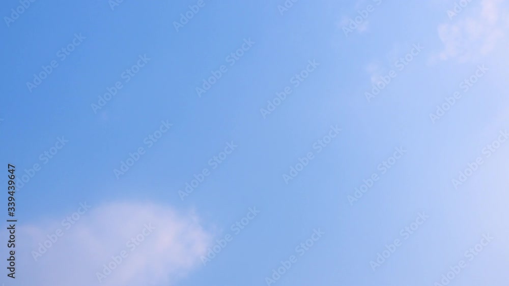 slow moving altostratus sheets of cloud are moving horizontal in the blue sky in day time. slow moving altostratus sheets of cloud are moving horizontal in the blue sky in day time.