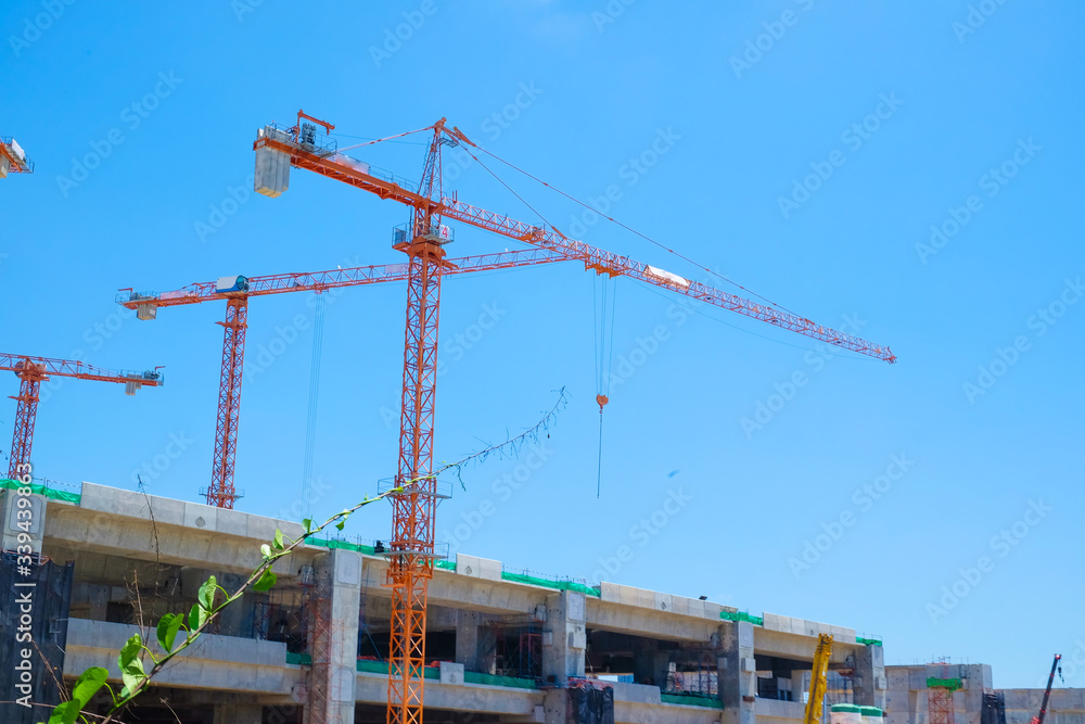 Construction building site with cranes against blue sky