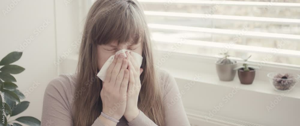 Woman cleaning nose with tissue coughing staying home during coronavirus covid 19 virus outbreak close up Woman cleaning nose with tissue coughing staying home during coronavirus covid 19 virus outbreak close up