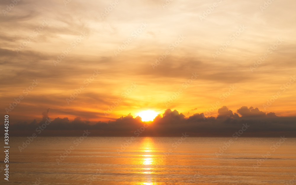 The rising sun over clouds in the sea. The morning light with a beautiful orange sky.