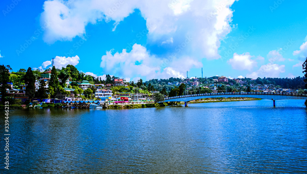 Bridge on the blue lake under white cloudy sky Bridge on the blue lake under white cloudy sky